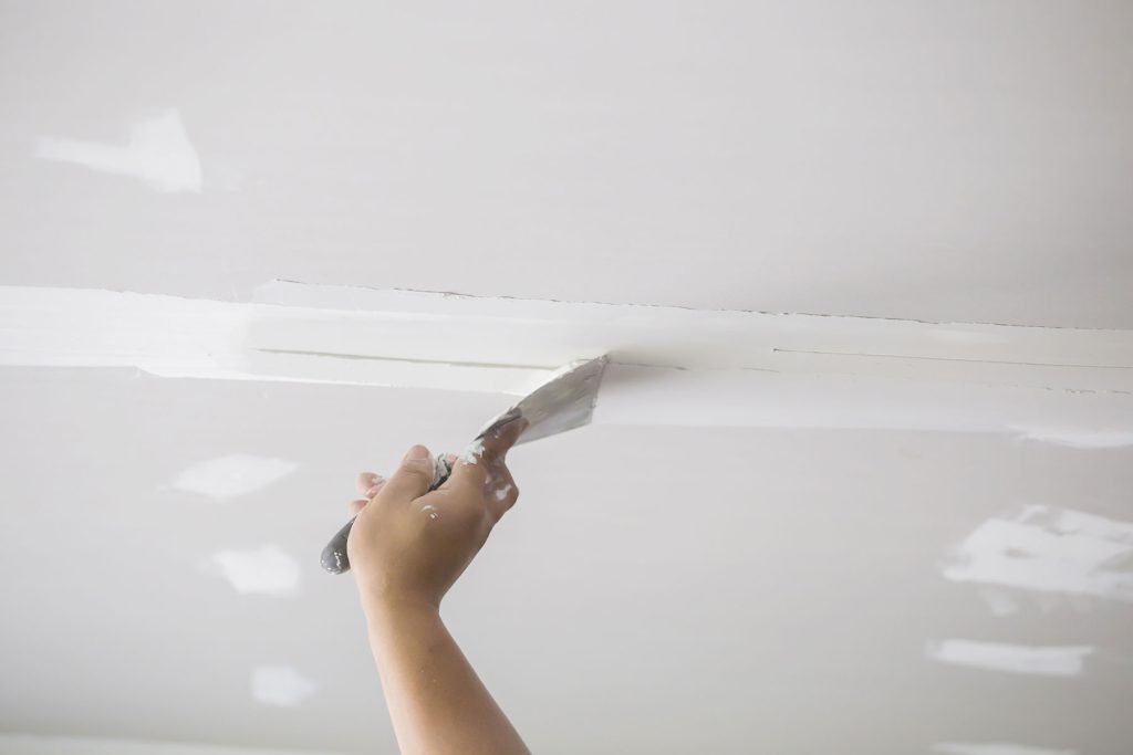 Amsted professionals install fresh drywall, creating a smooth surface.