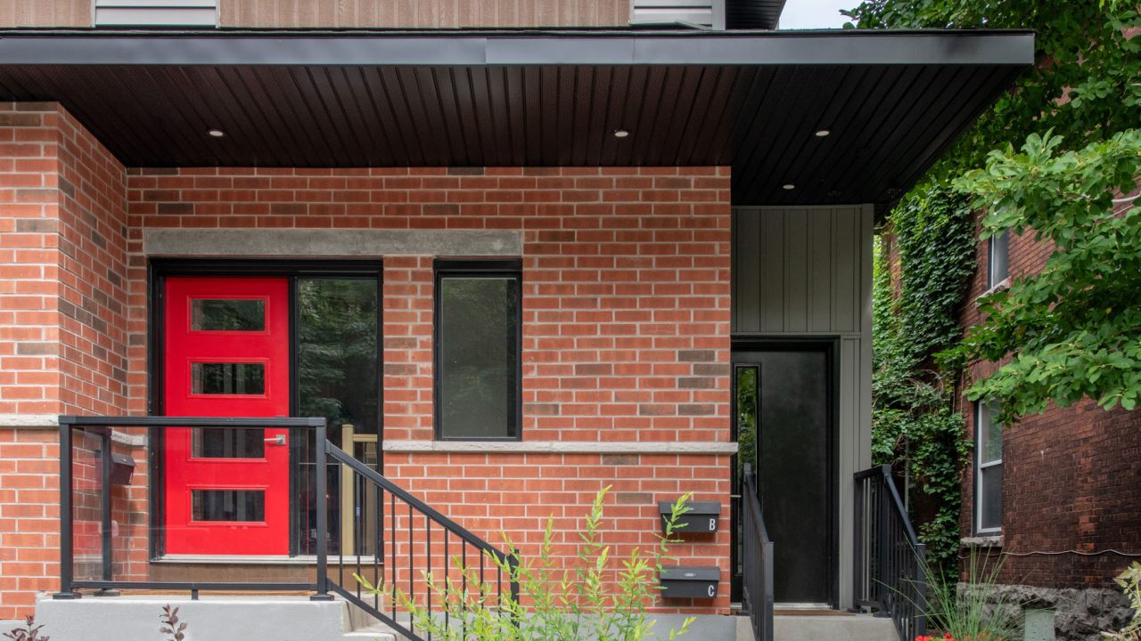 Aluminum stairs leading up to two residential units, including a newly installed additional dwelling unit by Amsted Design-Build, showcasing functional design.